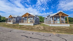 Two small cabins with wooden decks and a clear sky.