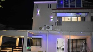 Een meerlaags gebouw met buitenverlichting en airconditioningsinstallaties.