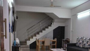 Een moderne woonkamer met een trap, een eethoek en een bank.