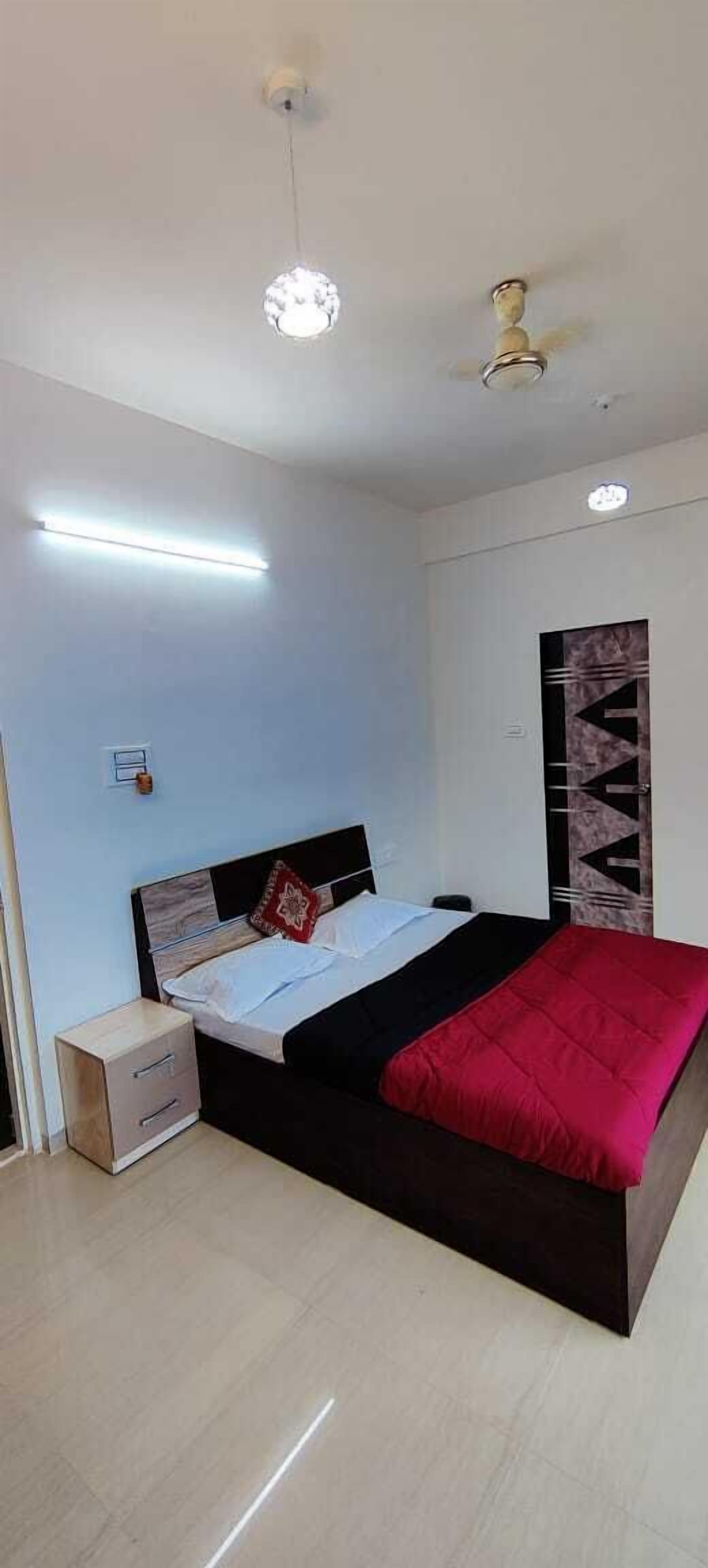 A bedroom with a bed, bedside table, and a ceiling fan.