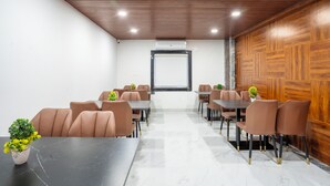 Une salle de conférence avec une longue table et des chaises, des murs recouverts de panneaux de bois et une grande fenêtre.
