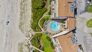 An aerial view of a hotel with a swimming pool, a beach, and a parking area. - Beachwalk 302 - Oceanfront, 4 Bedroom, 4 Bath Condo (Pine Knoll Shores)
