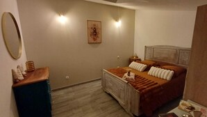A bedroom with a bed, a dresser, a mirror, and a wall-mounted picture.