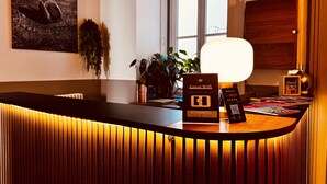 A hotel reception desk with a modern design, a sign for guest WiFi, and a lamp. - Bed & Chic art rooms (Trieste)