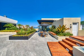 A rooftop patio with outdoor seating, a pool, and a view of the ocean. - Casa Mitzi – Your Stylish Escape in Zona Romántica (Puerto Vallarta)