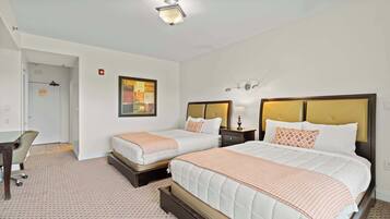 Une chambre d’hôtel avec deux lits, un bureau et une chaise.