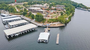 An aerial view of a lakeside hotel with multiple buildings, a marina with boats, and a dock.