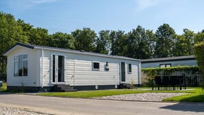 A single-story mobile home with a front door, a small window, and a garage door.