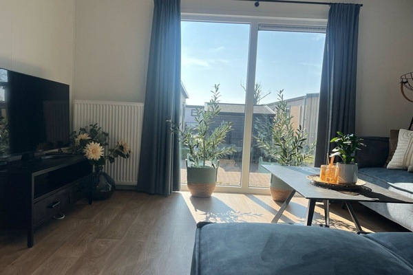 Salon avec télévision et canapé du parc de vacances De Zeeuwse Parel - Zeebaars