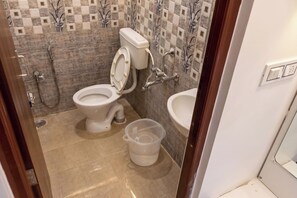 A bathroom with a toilet, shower, and sink. - JR Service Apartment  (Coimbatore)