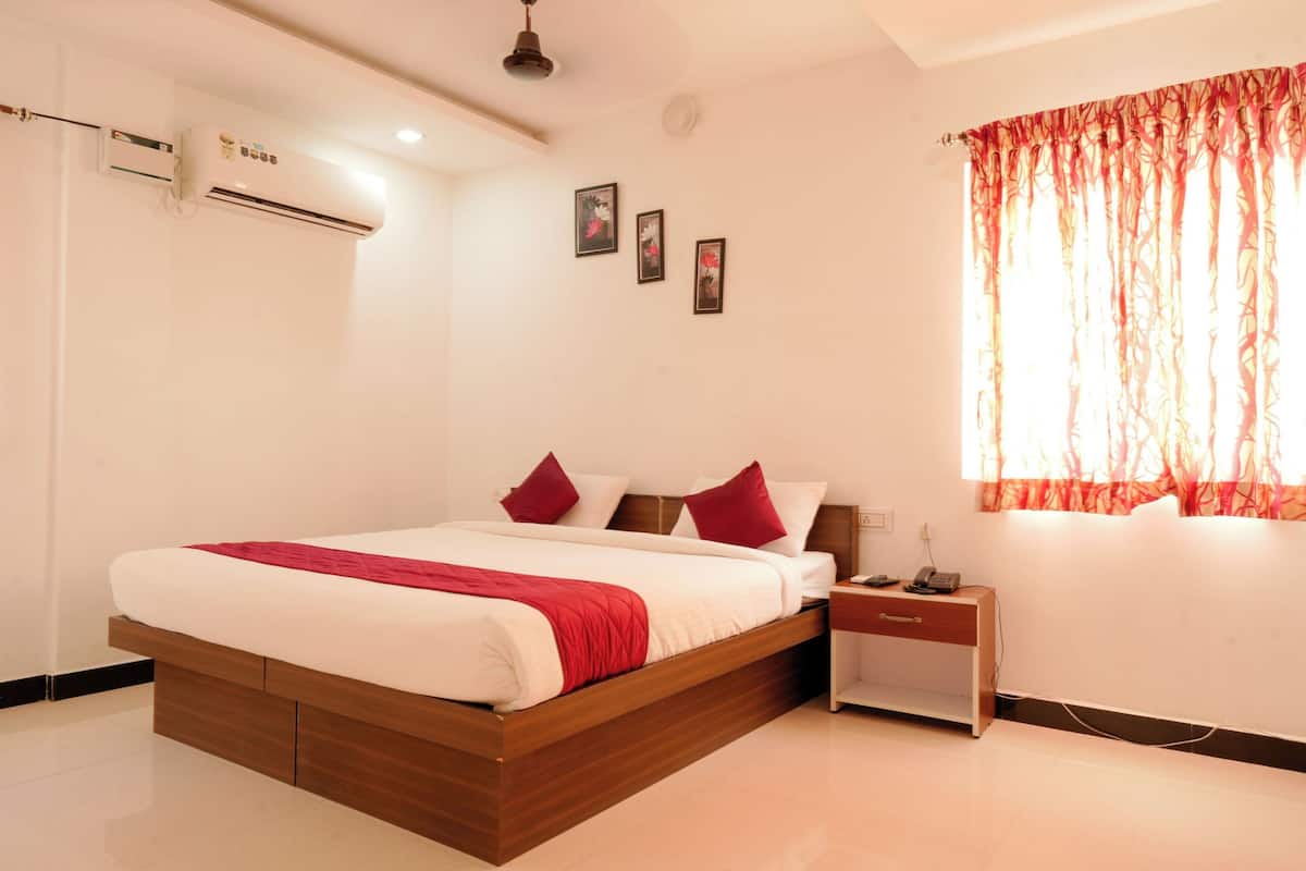 A modern bedroom with a wooden bed, a bedside table, an air conditioning unit, and a window with curtains.