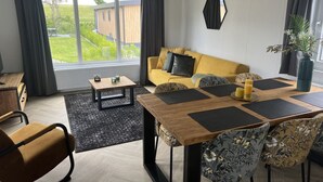 Una sala de estar moderna con un sofá, una mesa de centro y una zona de comedor.