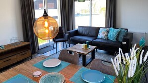 A modern living room with a sofa, coffee table, and dining area.