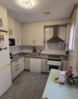 Una cocina compacta equipada con lavavajillas, horno y microondas.