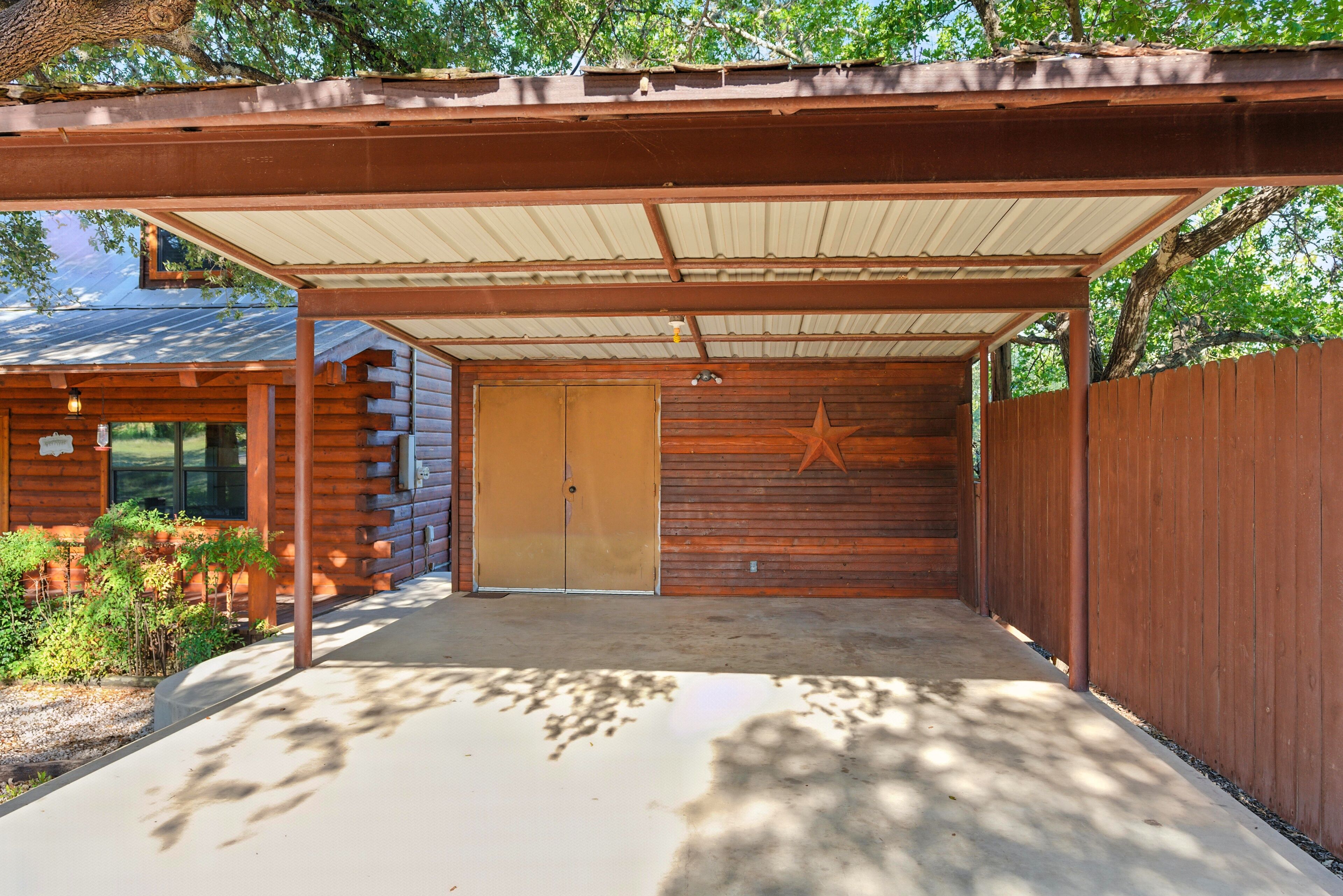 A covered outdoor area with a wooden fence, a star decoration, and a building with a metal roof.