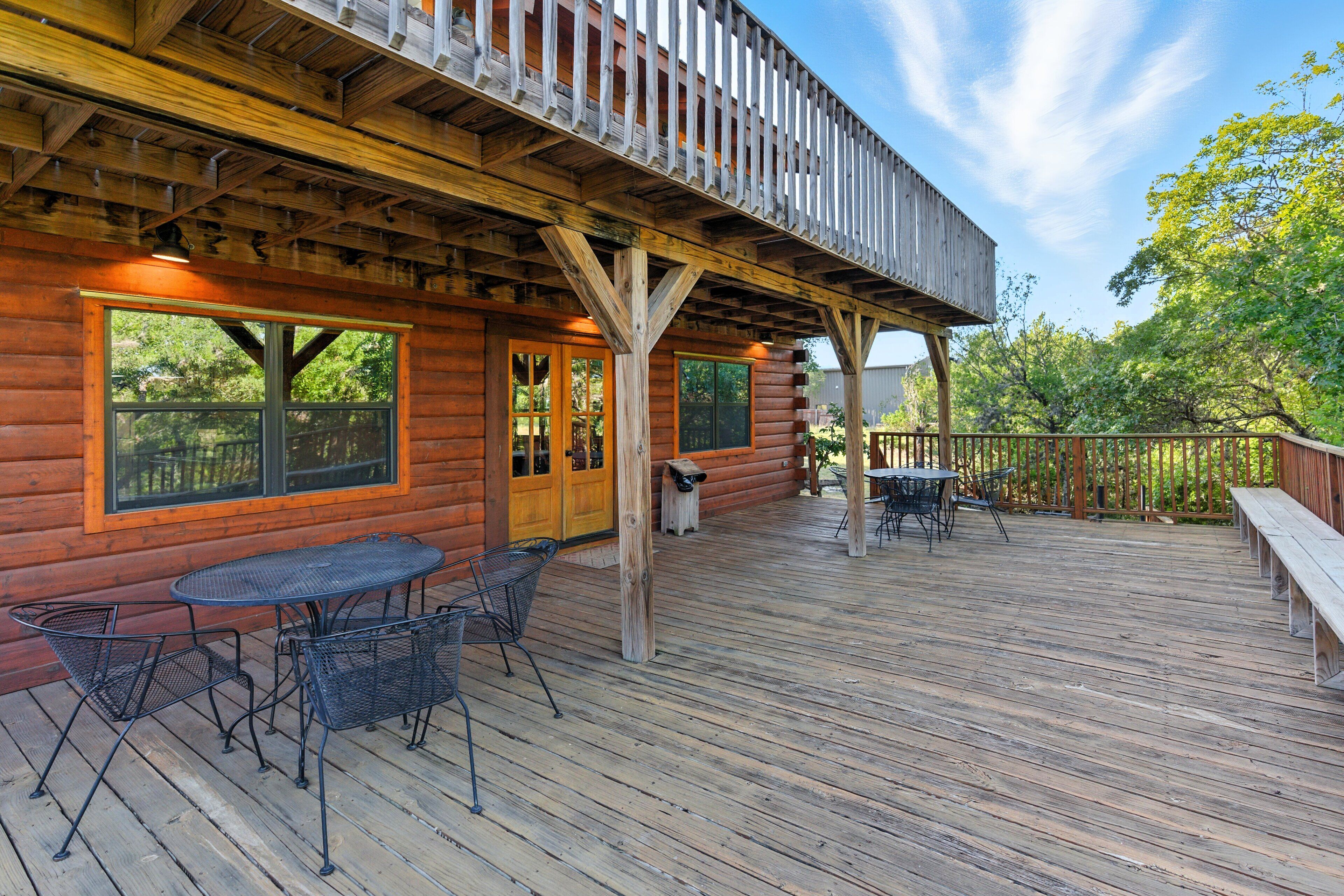 A wooden deck with outdoor seating and a covered area with a railing.