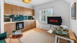 A modern kitchen with wooden cabinets, a built-in oven, and a dining area with a table set for two.