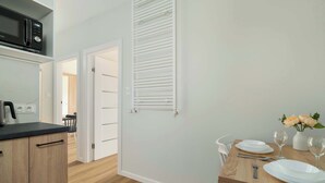 Eine moderne Küche mit Mikrowelle, Schränken und einem Essbereich mit Tisch für zwei Personen.