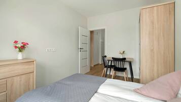 2 habitaciones, escritorio y tabla de planchar con plancha