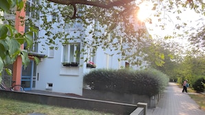 Un chemin menant à un bâtiment doté d’une fenêtre, d’un vélo et d’un jardinier.