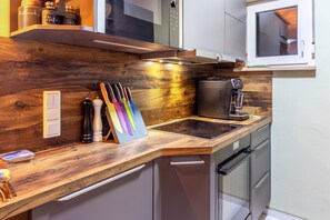 A kitchen with wooden countertops, a coffee machine, and a microwave.