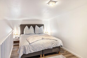 Une chambre à coucher avec un lit, des lampes de chevet et une table de nuit.
