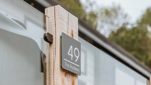 Un poste de madera con un letrero que dice '49 The Rookery'.