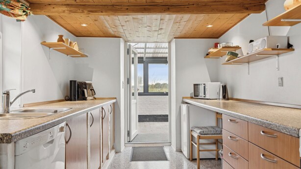 Eine moderne Küche mit Holzschränken, Granit Arbeitsplatten und integrierten Geräten.