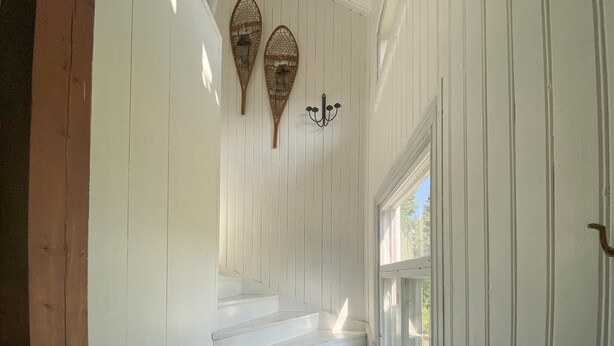 A staircase with white walls and wooden steps leading to a door with a glass panel. - Stunning home in Skillingaryd with sauna (Skillingaryd)