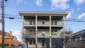 A multi-story building with a central entrance, balconies, and a parking lot. - Wildwood Studio Condo with a Pool (Wildwood)