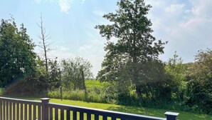 A wooden deck with a view of a grassy field and trees. - 3 bedroom accommodation in Brigg (Brigg)