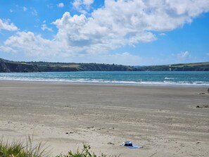 A beach with a clear sky, calm sea, and distant hills. - It feels like a true escape, yet so easy to reach. (Preseli Hills)
