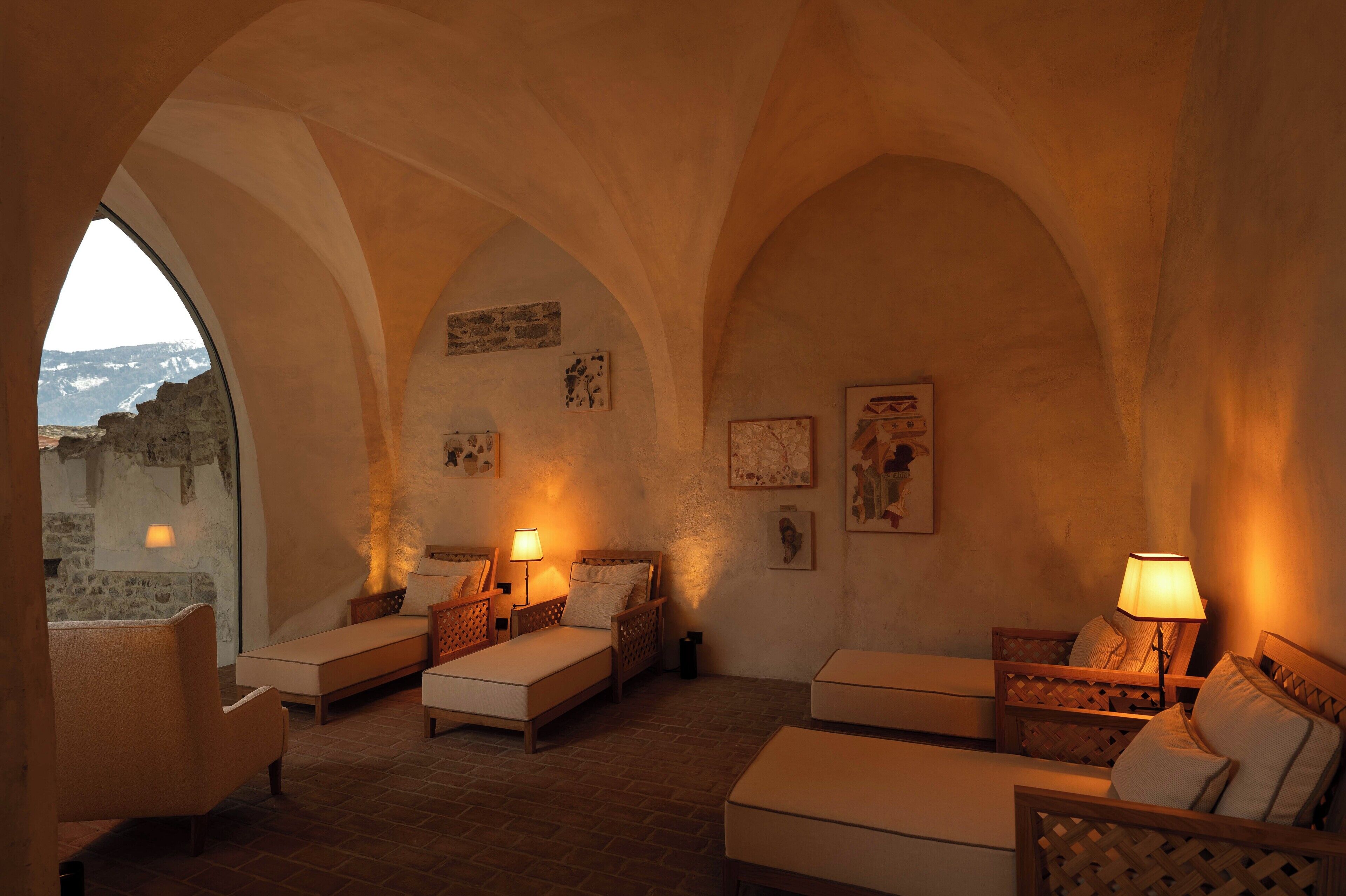 Una habitación acogedora con pared de piedra, cama, sofá y sillón.