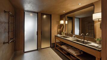 Un baño moderno con lavamanos doble, un espejo grande y un perchero para toallas.