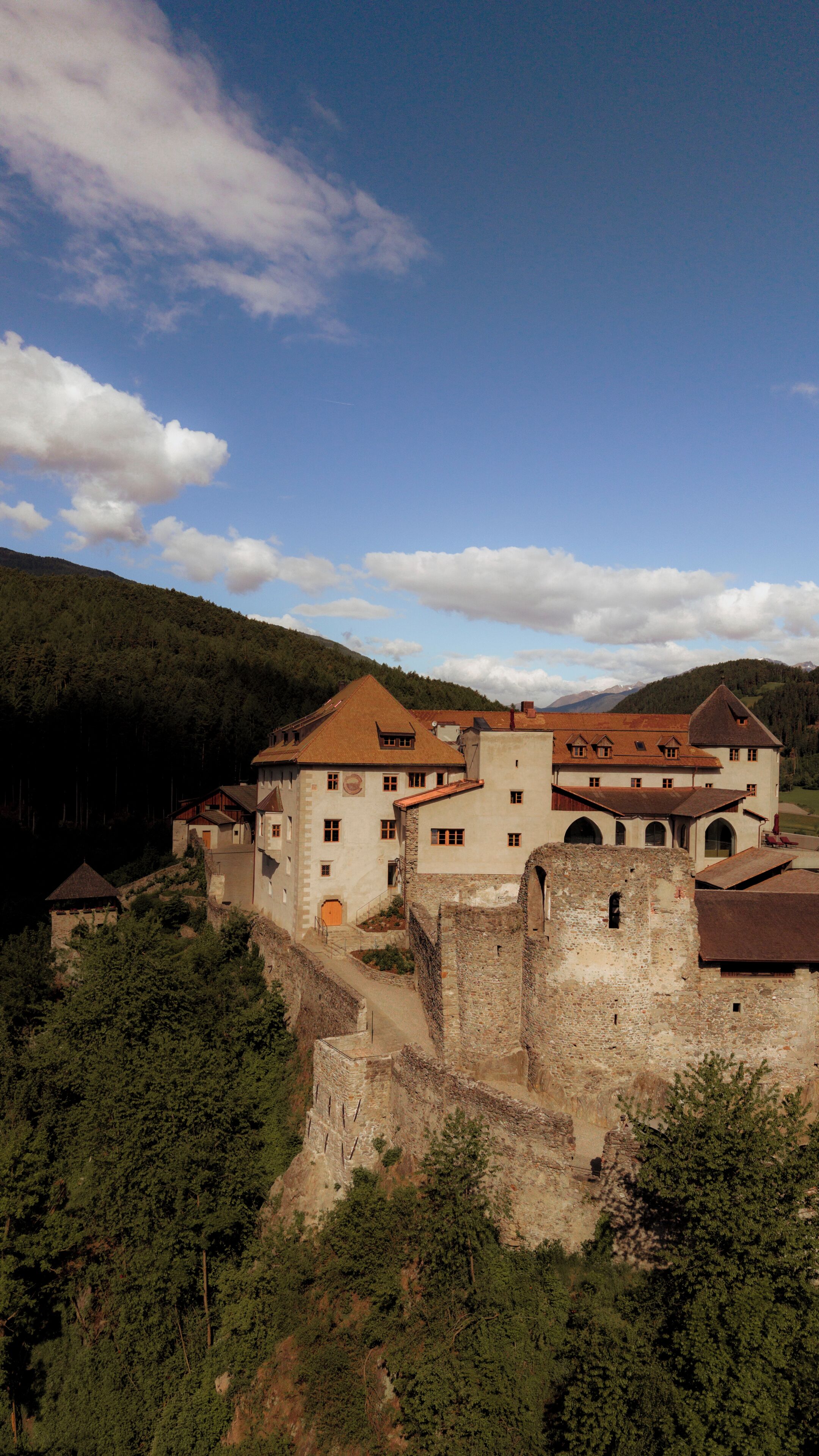 A historic building complex with multiple structures, including a castle-like fortification and residential buildings with traditional architecture.