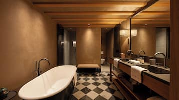 Un baño moderno con una bañera independiente, un espejo grande y un piso de pisos.