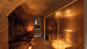 A hallway with a stone wall, a glass door, and a staircase leading to an upper level. - Castel Badia (San Lorenzo di Sebato)