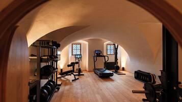 Una palestra con attrezzature per esercizi, tapis roulant e macchinari per sollevamento pesi.