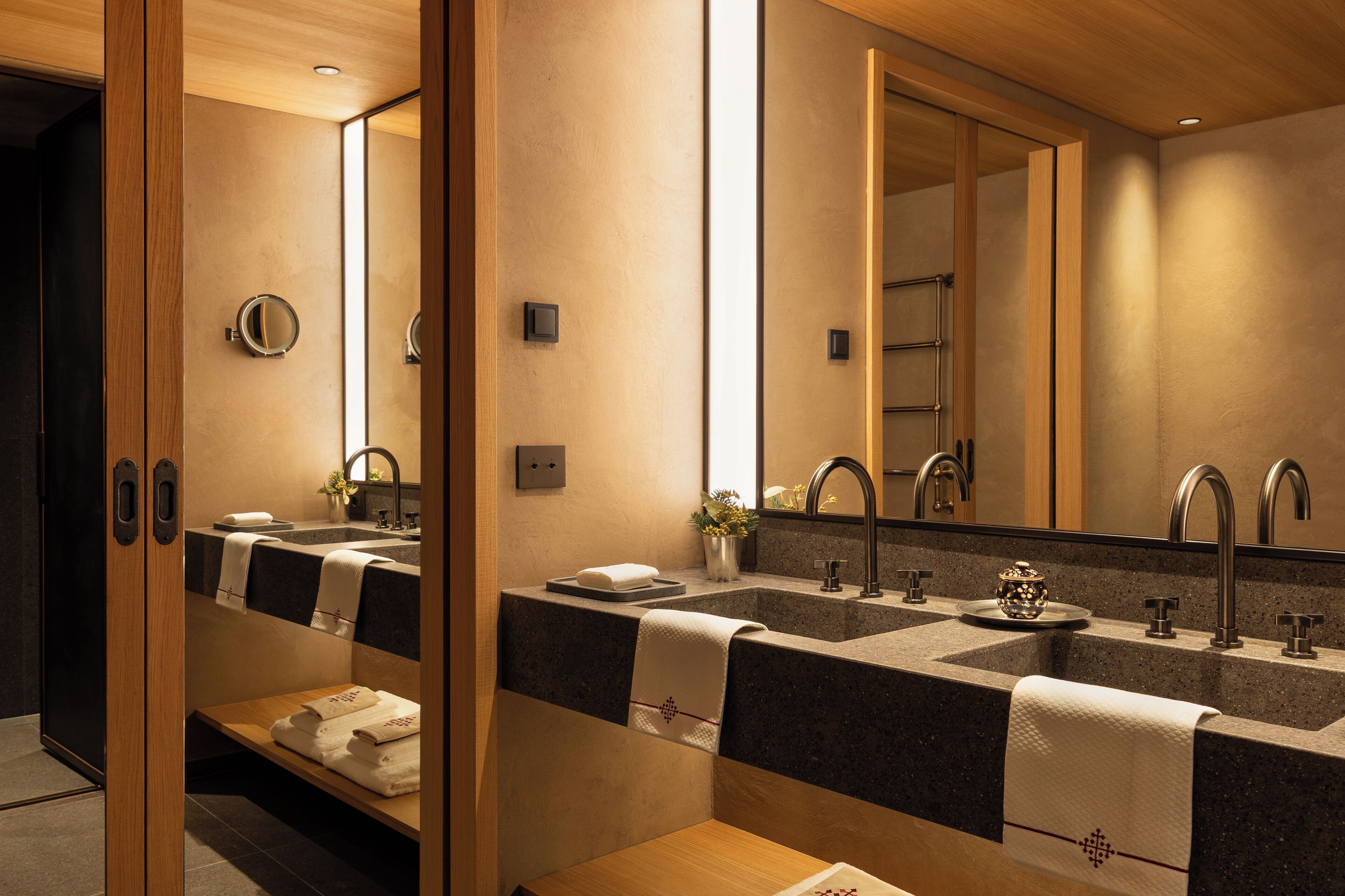 Ein modernes Badezimmer mit zwei Waschbecken, einem großen Spiegel und einem Handtuchhalter.