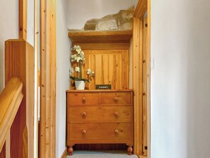A wooden dresser with a label 'Laundry' and a potted orchid in a white pot.