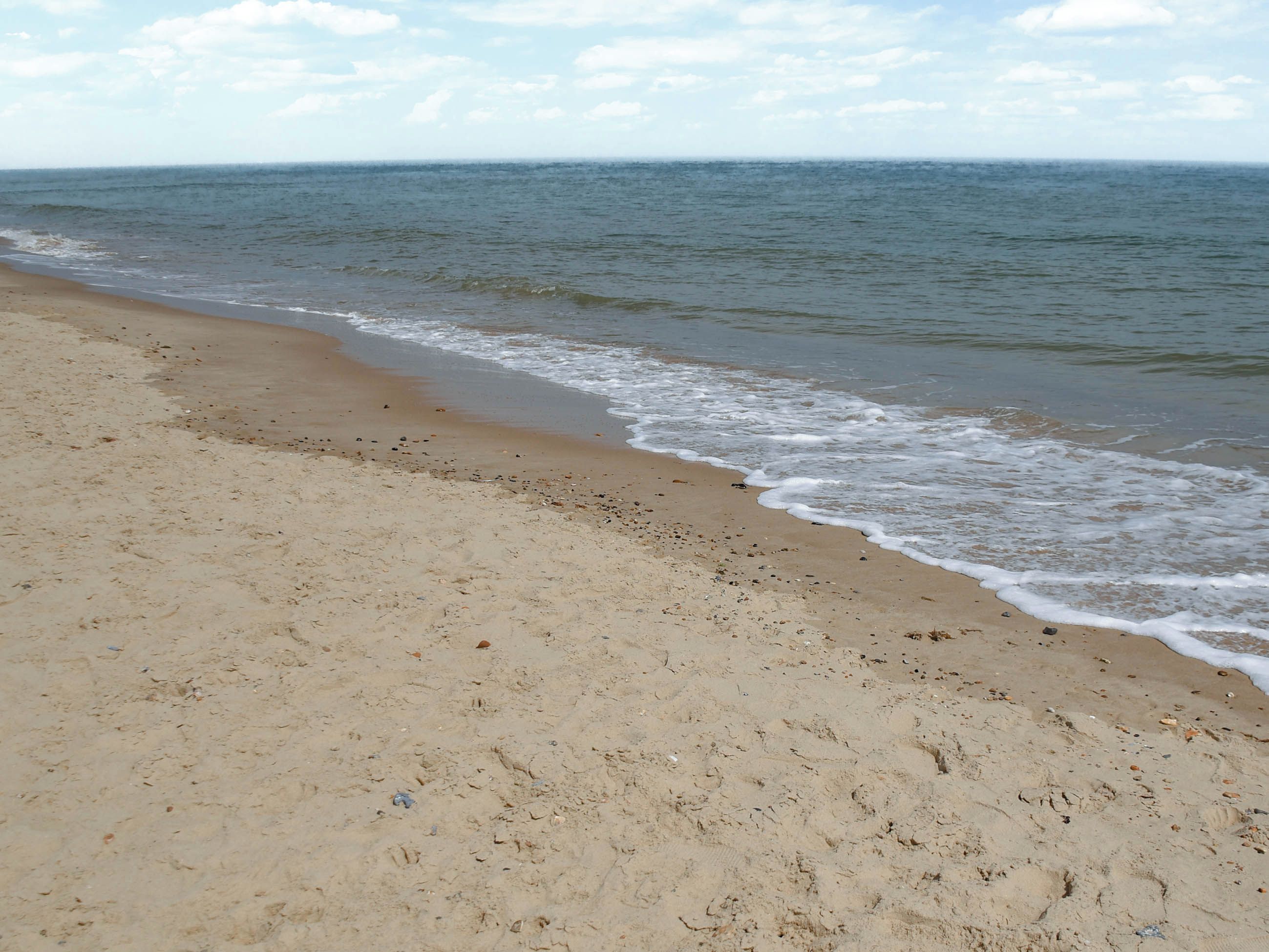 A sandy beach with gentle waves.