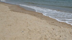 A sandy beach with gentle waves. - This seaside retreat blends modern comfort with spectacular sea views. (Bacton)