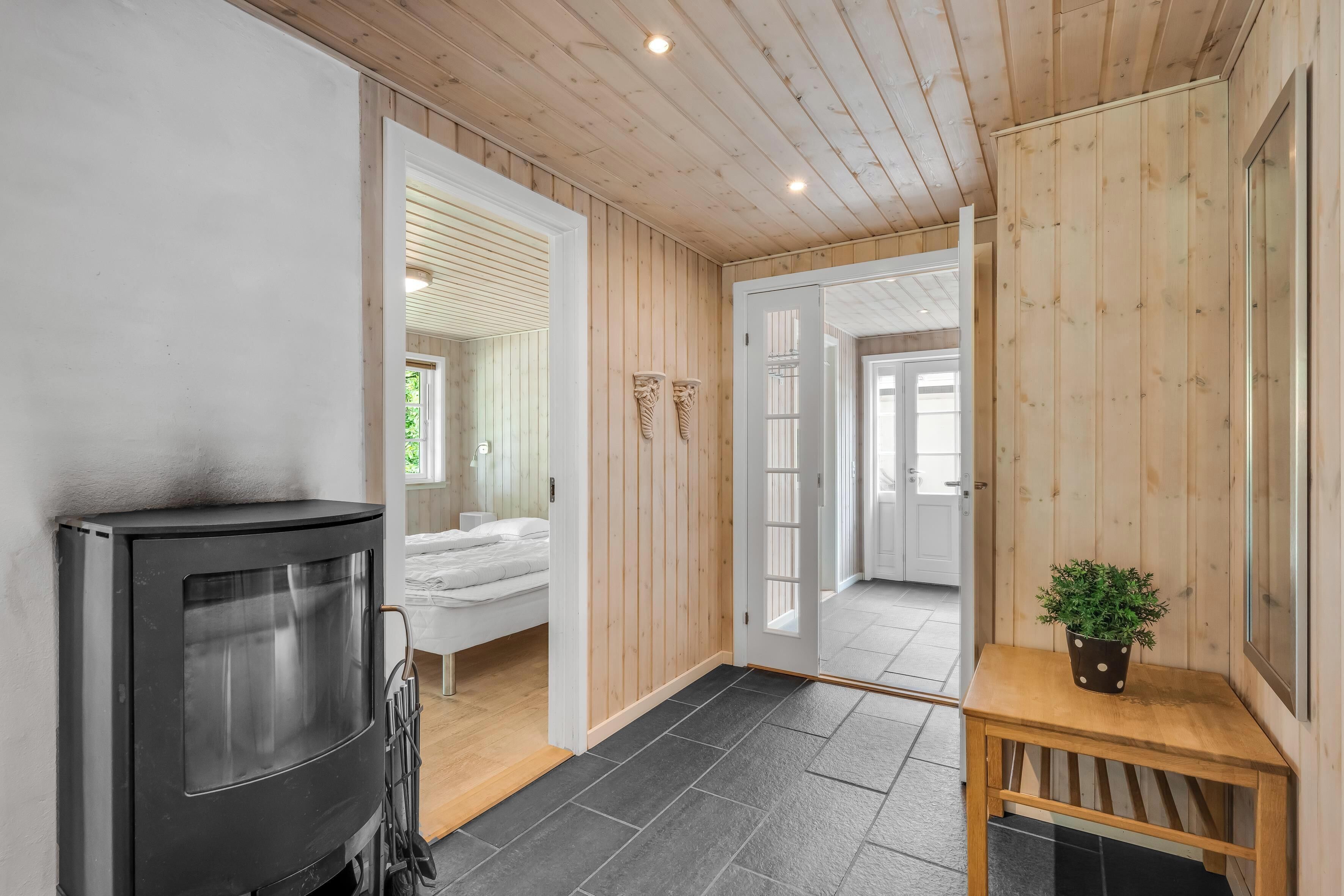 Ein gemütliches Zimmer mit Kamin, einem Bett und einem kleinen Tisch mit Pflanze.
