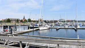 Un port de plaisance où sont amarrés de nombreux bateaux, avec des passerelles en bois et une église en arrière-plan.