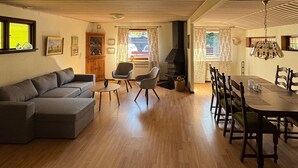 Un salon comprenant un canapé, des fauteuils, une table à manger et une cheminée.