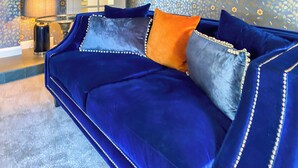 A blue sofa with decorative pillows and a patterned wallpaper in a room. - 3 bedroom accommodation in Featherstone, near Wakefield (Featherstone, near Wakefield)