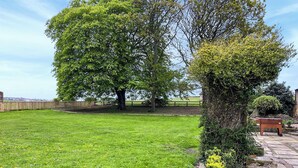 A well-maintained grassy yard with a stone pathway and a wooden fence. - 3 bedroom accommodation in Featherstone, near Wakefield (Featherstone, near Wakefield)