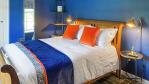 Ein Schlafzimmer mit einem hölzernen Bett, blauen Wänden und zwei Nachttischlampen.