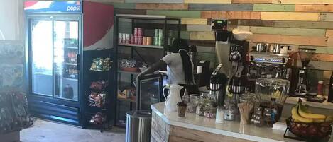 A coffee shop interior with a wooden counter, espresso machines, and a menu board.
