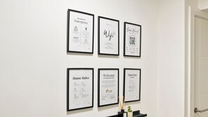 Framed documents on a wall, including emergency services, WiFi, house rules, and a welcome message. - 10%OffWeekly - The Blue Suite Family & Business Stays (Sevenoaks)